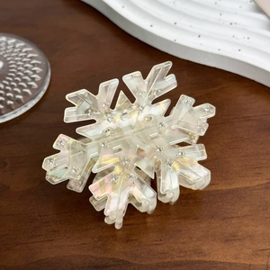Macro detail of snowflake hair claw clip with iridescent finish and inlaid rhinestones