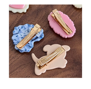 Vue détaillée de barrettes à cheveux mignonnes en acrylique avec pinces en métal doré