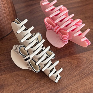 Elegant French vintage bow hair claws in cream white and pink on a wooden background