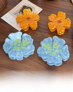 Gros plan de pinces à cheveux en acétate marbré en forme de fleur avec strass