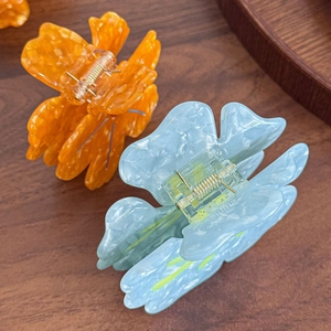Pinces à cheveux fleurs en acétate avec strass et texture marbrée en orange et bleu clair