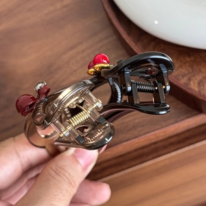 Elegant hair claw clips set with cherry and bow accents in black and amber resin