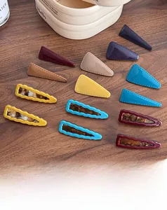 Detail of colorful geometric hair clips with amber texture on a rustic wooden desk