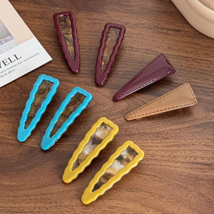 Set of 8 vintage acetate drop hair clips in mixed colors on a wooden surface