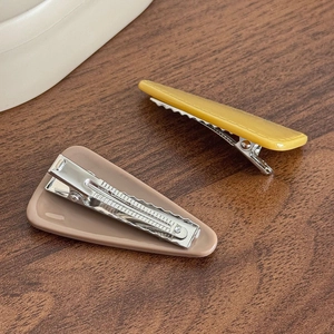 Pair of minimalist triangular hair clips in matte brown and mustard yellow finish