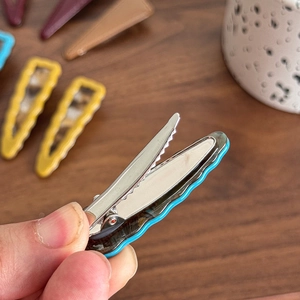 Blue and brown patterned hair clip with wavy edges and silver metal teeth grip