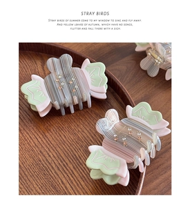 Detail showing candy-shaped acetate hair claw with rhinestones on a wooden tray