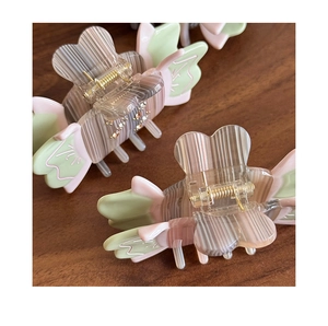 Detailed view of butterfly claw clip with brown stripes and pastel acetate accents