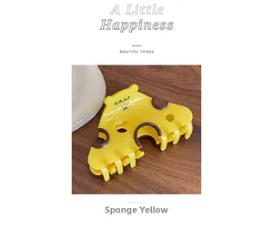 Détail d'une pince à cheveux évidée en forme de fromage jaune éponge sur bois