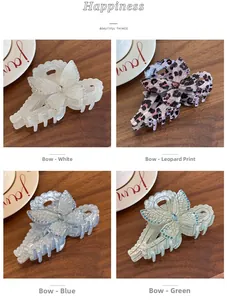 Detail of four butterfly hair claws in white, leopard, blue, and green with rhinestones