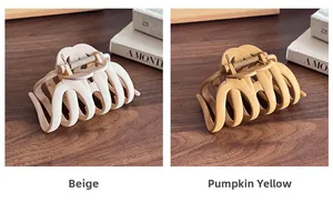 Detail view of beige and pumpkin yellow matte hair claws with metal spring mechanism