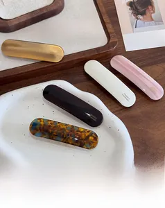 Détail de pinces à cheveux en acétate montrant le logo France Handmade sur un plateau