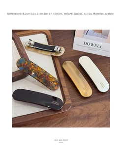 Gros plan de barrettes en acétate fait main montrant textures vintage et mécanisme