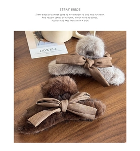 Close-up of plush faux fur hair claw clips with fabric bows on a wooden surface