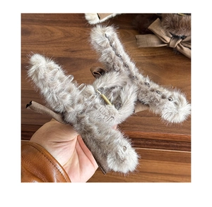 Close-up of brown plush H-shaped hair claw clip with bow and soft faux fur texture