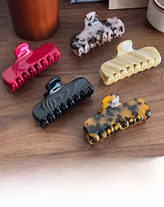 Selection of acetate shark hair claws in tortoiseshell and marble patterns on wood