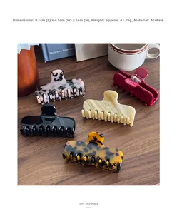 Detail view of 9.1cm acetate hair claws in various patterns on a vintage wooden desk