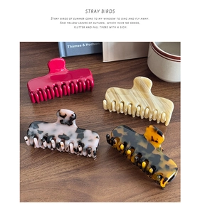 Detailed view of four acetate hair claws in rose, cream, and tortoiseshell patterns