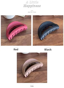 Detail view of three matte hair claw clips in red, black and brown colors