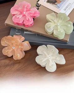 Detail view of floral acetic acid hair claws with subtle gradients and sparkling rhinestones