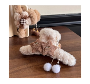 Detail of plush bow claw clips with star accents and dangling pearl tassels decoration
