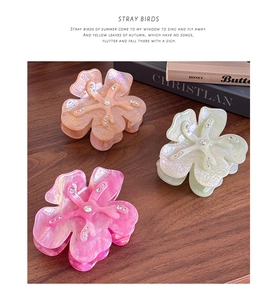 Detailed view of floral hair claws with acetate finish and sparkling rhinestones