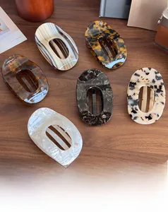 Flat acetate hair claws in various vintage marble patterns on a rustic wooden table