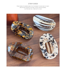 Detail view of four large acetate hair claw clips with classic tortoiseshell and marble patterns
