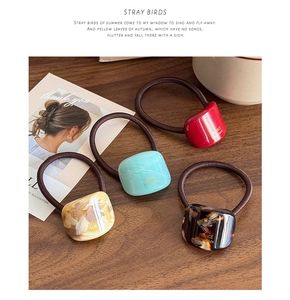 Detail of four handmade acetate hair ties with marble and tortoiseshell patterns