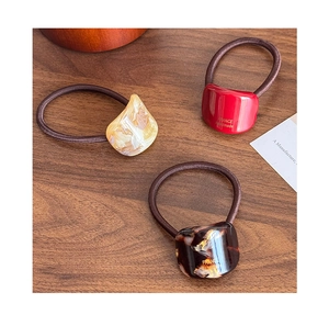 Detailed macro view of acetate geometric hair ties in marble, red and tortoise patterns