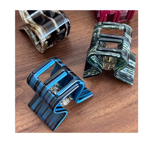 Detail view of acetate claw clips showing marbled texture and strong metal spring