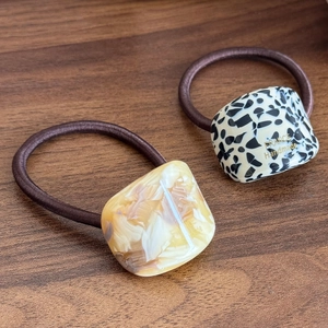 Set of two elastic hair ties with black spotted and amber marble acetate geometric cubes