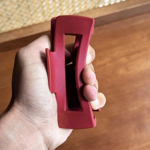 Matte burgundy rectangular hollow hair claw clip held by hand for thick hair styling