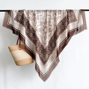 Close-up of lightweight linen square scarf with geometric floral print and frayed edges