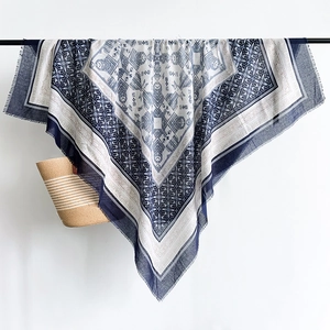 Detail view of ethnic blue and white cotton linen scarf with frayed tassel edges