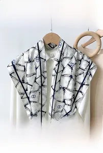 Detail of the geometric pattern scarf on a white shirt with elegant wooden ring accents