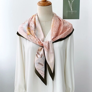 Floral print silk scarf in pink and brown tied on a white shirt mannequin