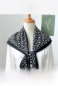 Close-up of a minimalist black and white diamond print silk scarf tied on a white shirt