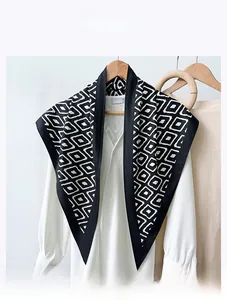 Detail view of black and white diamond pattern scarf on a white shirt with velvet-like texture