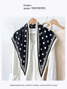 Detail of classic black and white polka dot scarf with silky texture on a white shirt