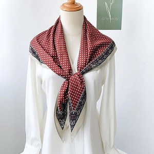 Elegant red square scarf with paisley and floral prints, worn over a white shirt