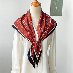 Detailed texture of dark red floral silk scarf with contrasting black and white borders