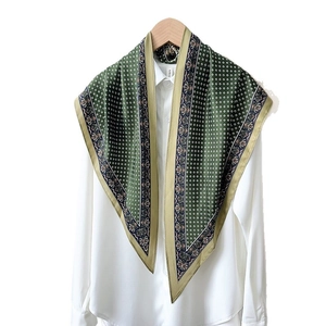 Silk scarf with cashew plaid pattern in dark green and gold trim on white shirt