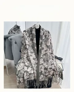 Close-up of floral cashmere feel scarf featuring pink camellia patterns and tassel fringe