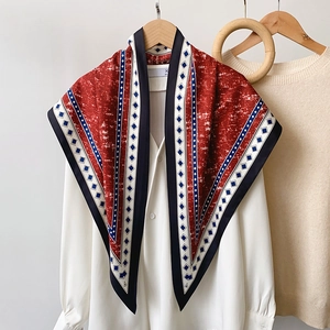 Detailed view of the silk scarf with blue denim print and red geometric patterns