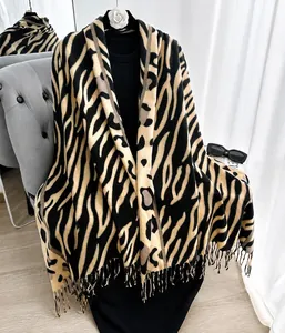 Vista detallada de la bufanda gruesa con estampado de leopardo y cebra y bordes de flecos