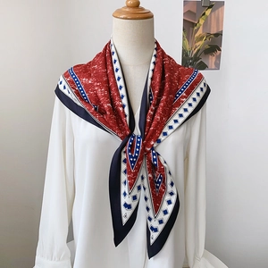 Retro denim blue silk scarf with geometric print and polka dots worn as a stylish shawl