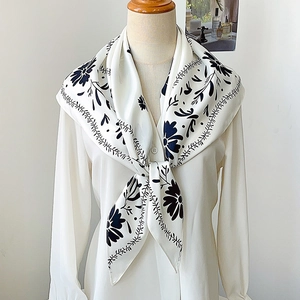 Chic black and white floral print silk scarf styled as a shawl on a white blouse