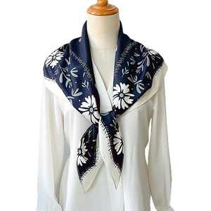 Elegant navy blue floral satin silk scarf with white flowers on a mannequin neck