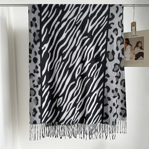 Detalle de una bufanda con estampado de leopardo y cebra con flecos en blanco y negro